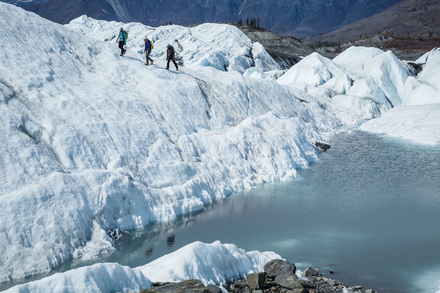 Guides-walking-across-glacier three people walking across a glacier