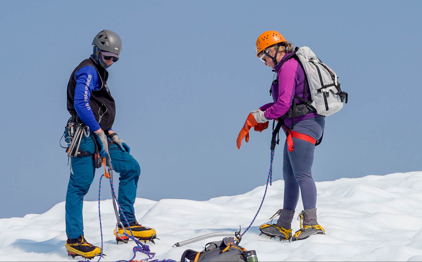 glacier guide and guest put on glove