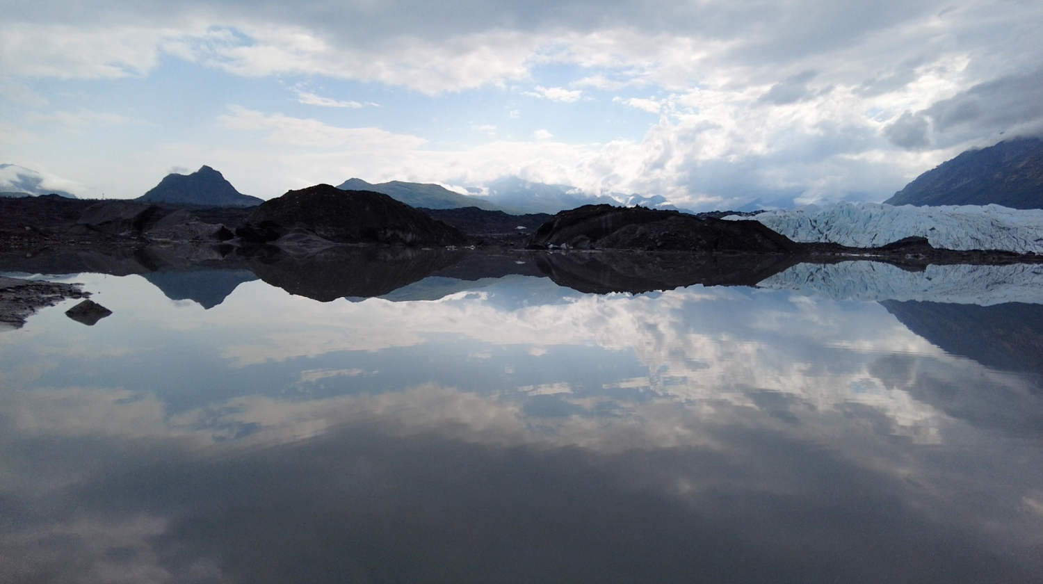reflection of sky on glacier meltwater