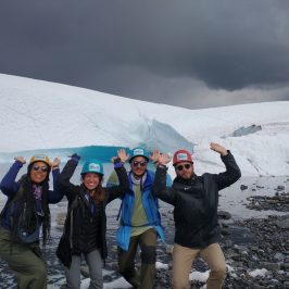 a group of people standing on top of a snow covered mountain