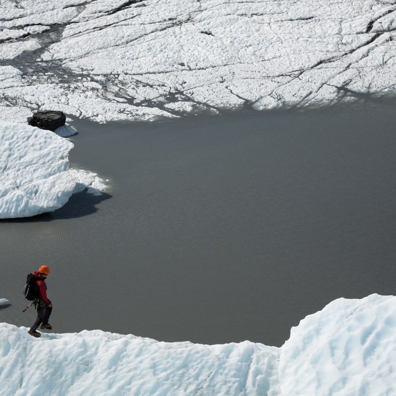 person walking next to lake and ice