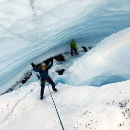 a man riding skis down a snow covered mountain