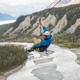 person curled up going down a zipline