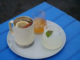 three cocktails on a white plate on a blue table