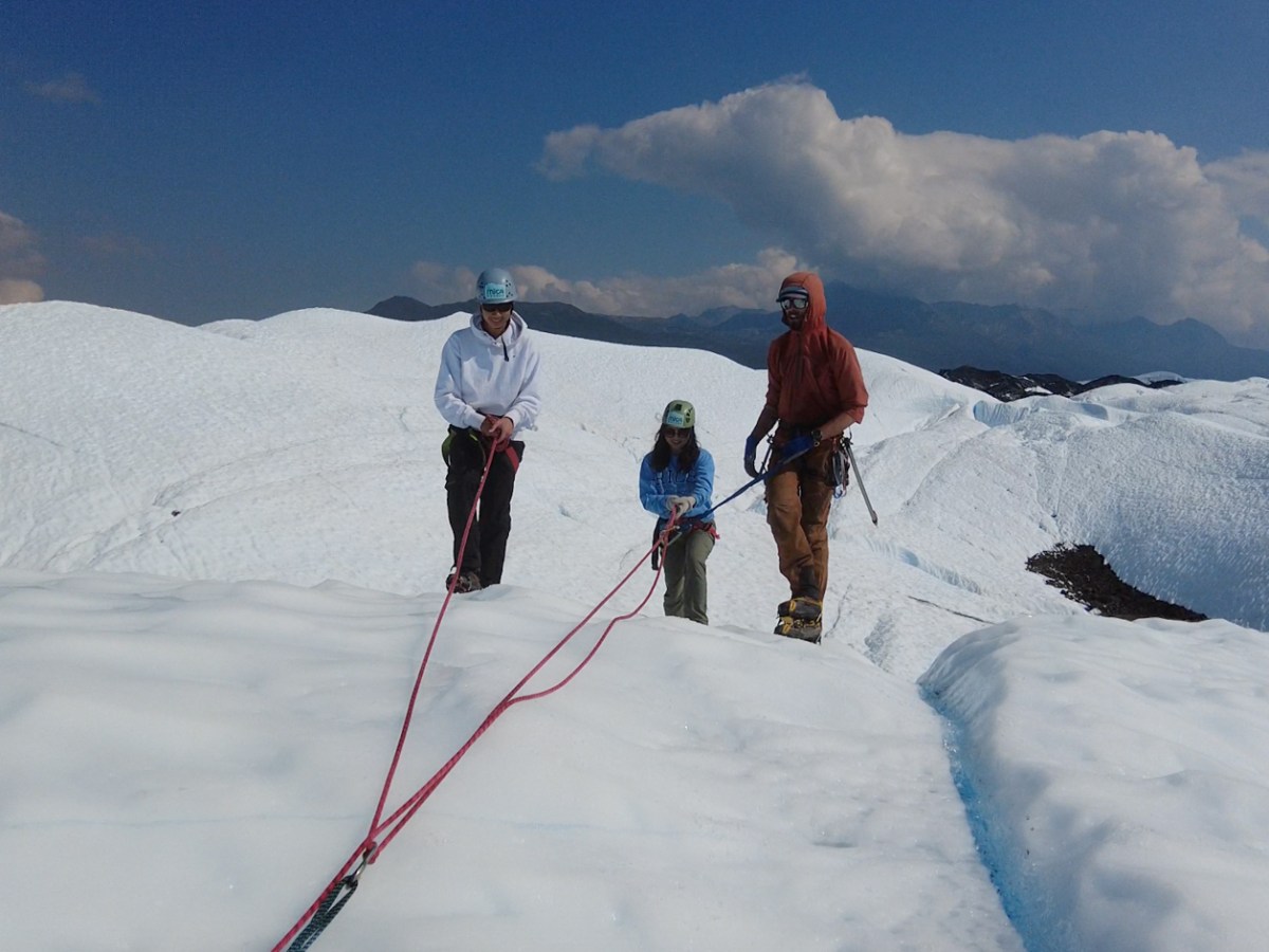 three people using simple rope systems on glacier ice