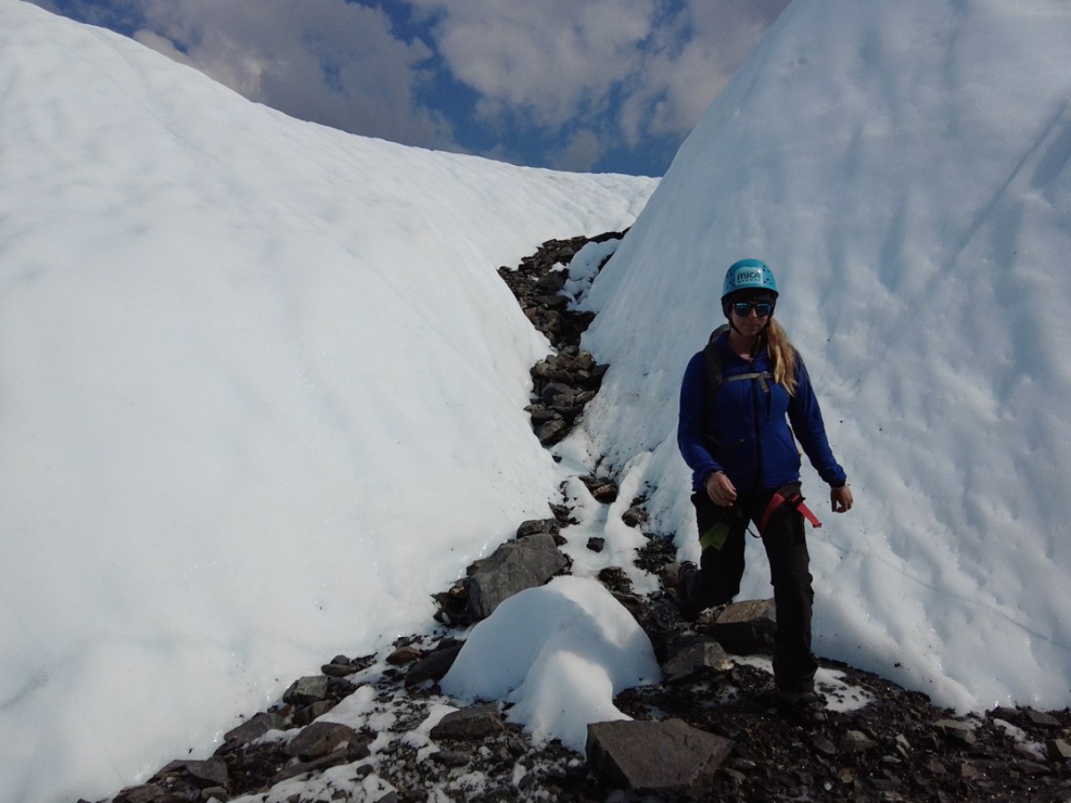a person walking down a glacier canyon