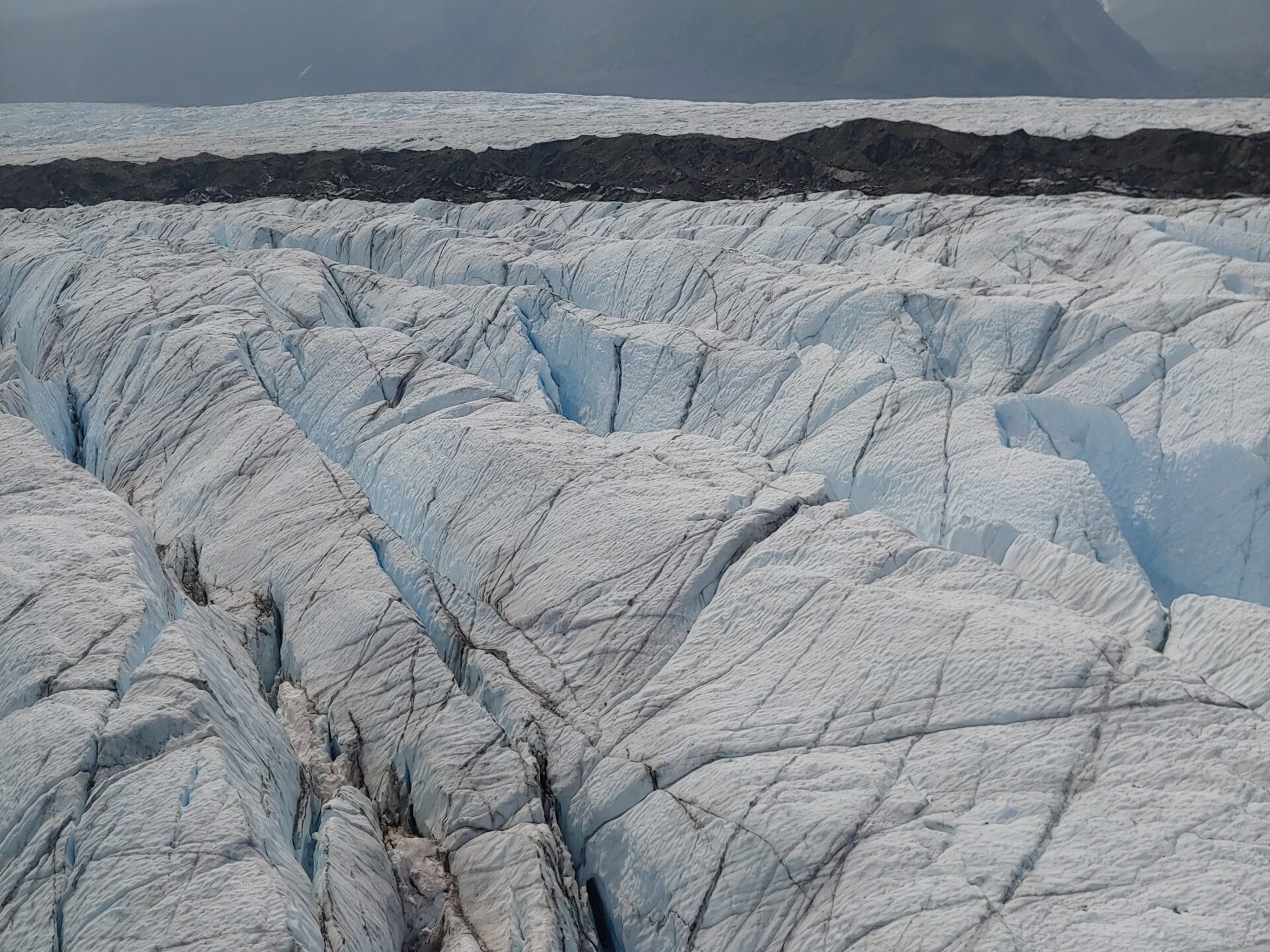 a view of a mountain and white ice and rocky moraine