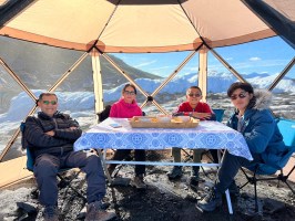 a man and woman sitting on a bench next to a body of water