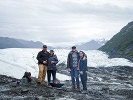 a group of people standing in a glacial valley on moraine