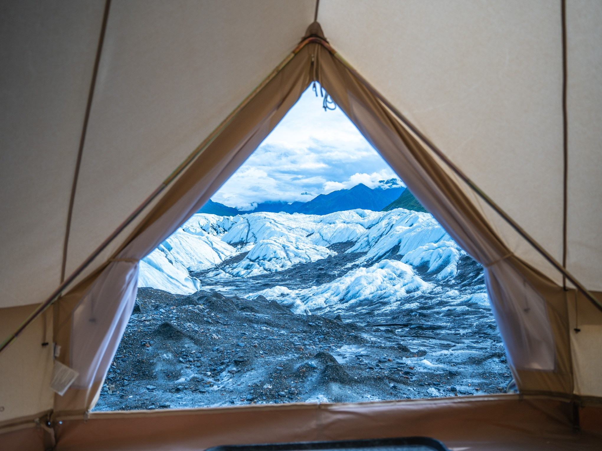 View from inside canvas tent of glacier and mountains in Alaska