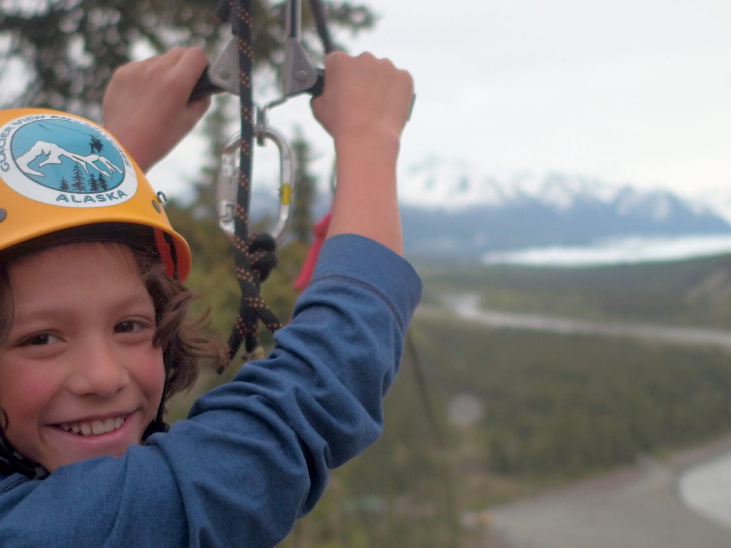 Boy wearing helmet for ziplining and smiling