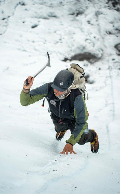 a person riding a snowboard down a snow covered slope