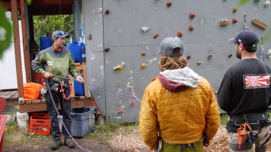 MICA Guides practicing their training skills by a rock wall